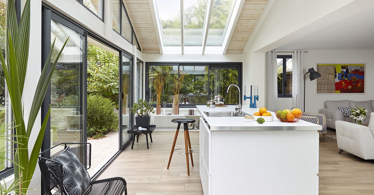 Exemple de véranda moderne : espace lumineux, ouvert sur le jardin, avec baies vitrées aluminium.
